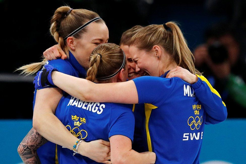 Team Sweden hug each other in celebration