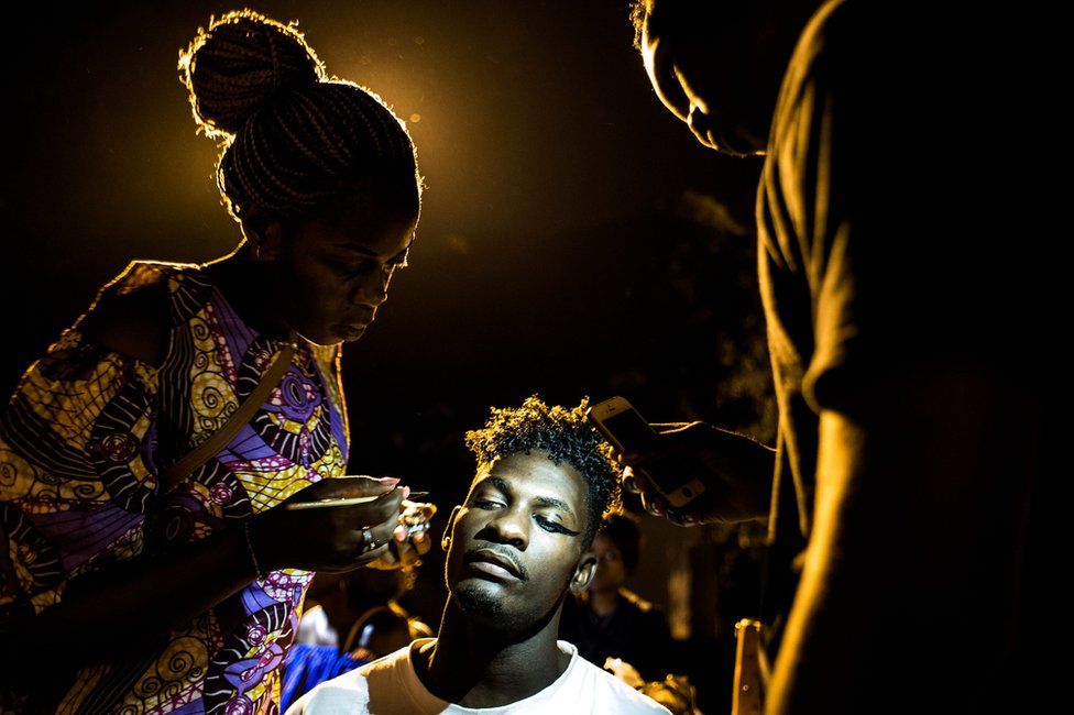 A Congolese fashion model is seen whilst she prepares her makeup backstage ahead of the Kinshasa Fashion Week on October 14, 2017 in Kinshasa.