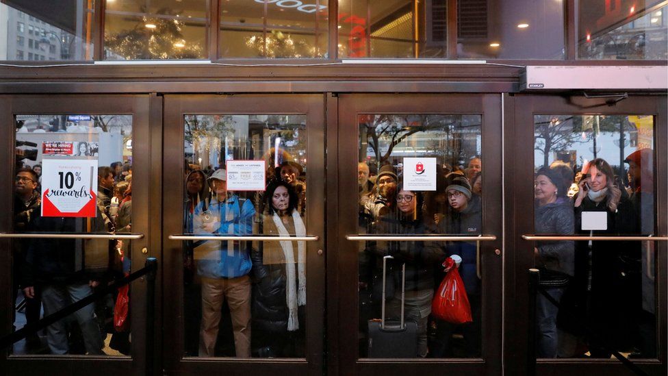People gather at the Broadway entrance of Macy's Herald Square store ahead of early opening for the Black Friday sales in Manhattan, New York, US
