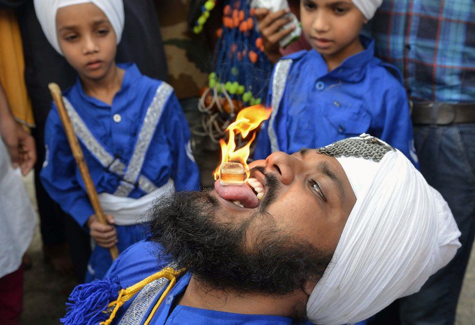 A warrior holds a flaming cube on his tongue.