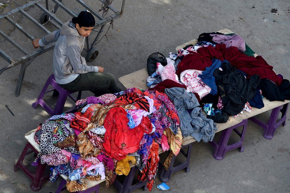 A Tunisian boy sells clothes at a market in the centre of Tunis on April 14, 2017. AFP PHOTO / FETHI BELAIDFETHI