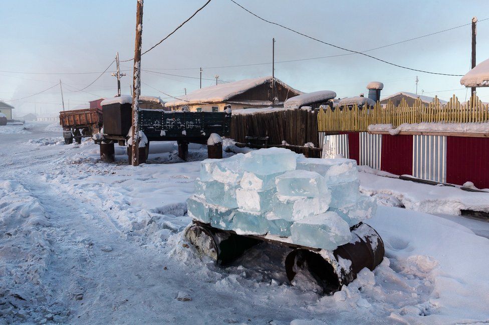 To ensure the village’s water consumption, men cut blocks of ice into the river and deliver them to the inhabitants. Each house has its own stock of water stored outside in stacks of ice blocks.