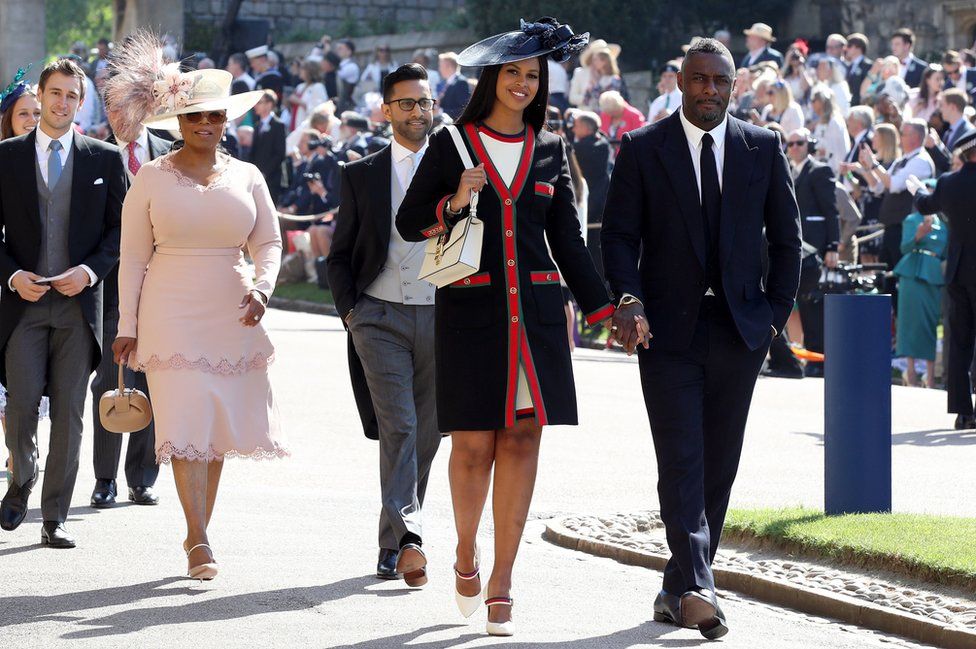 Idris Elba and Sabrina Dhowre, followed by Oprah Winfrey, arrive at St George's Chapel