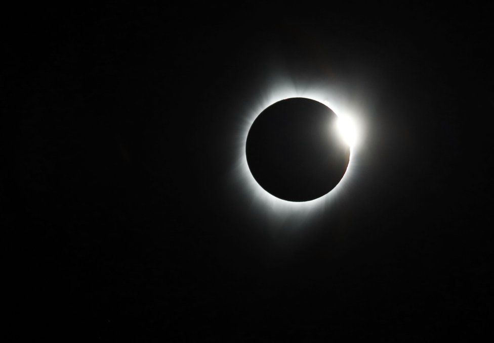 Sol atrás da lua em Sisters Oregon, nos EUA.