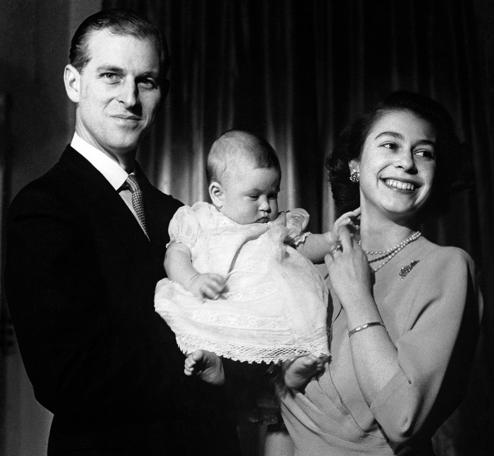 Princess Elizabeth and the Duke of Edinburgh holding Prince Charles