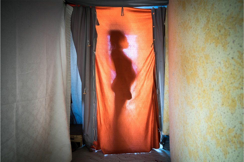 Mohamed Fatima is silhouetted against a sheet