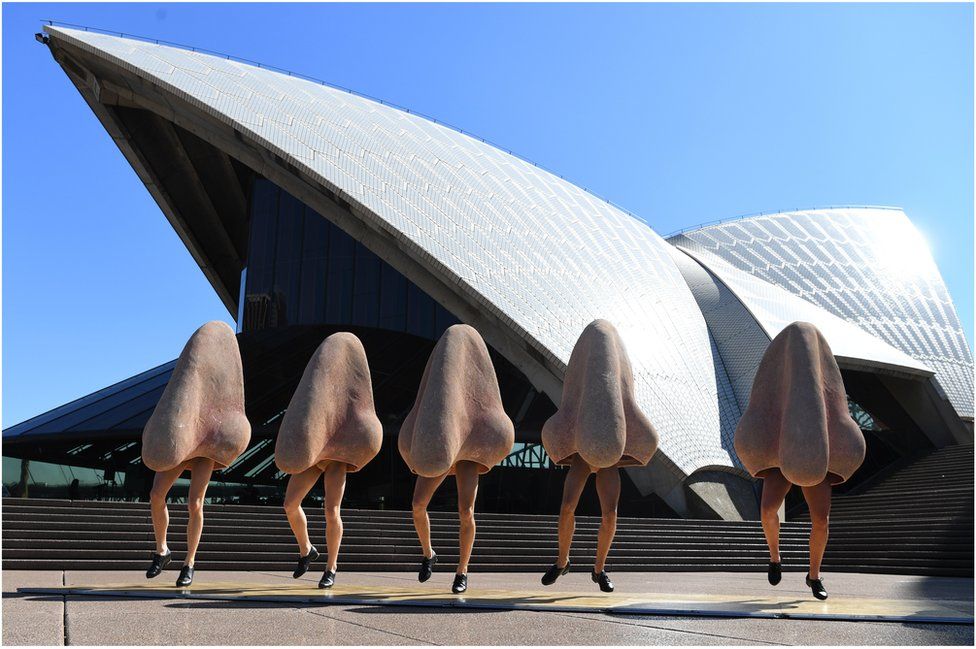 A row of noses dance in front of the Opera House