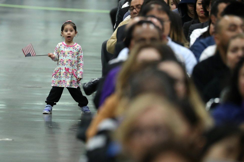 A small girl waves an American flag.