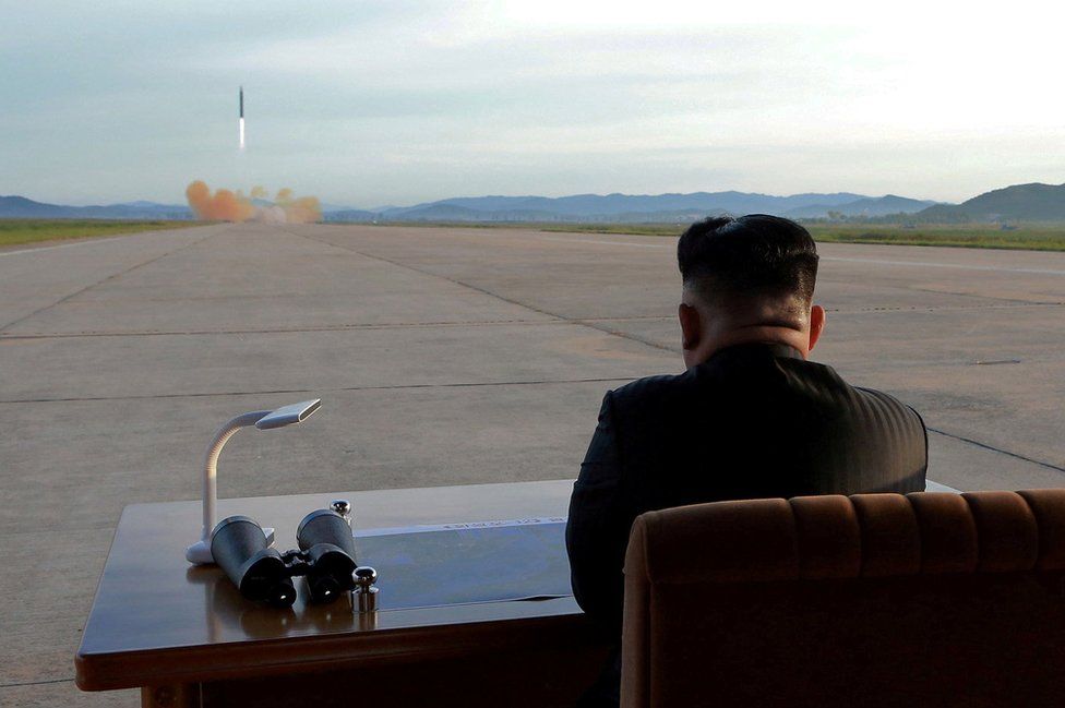 Kim Jong Un assiste, numa escrivaninha, ao lançamento de um míssil