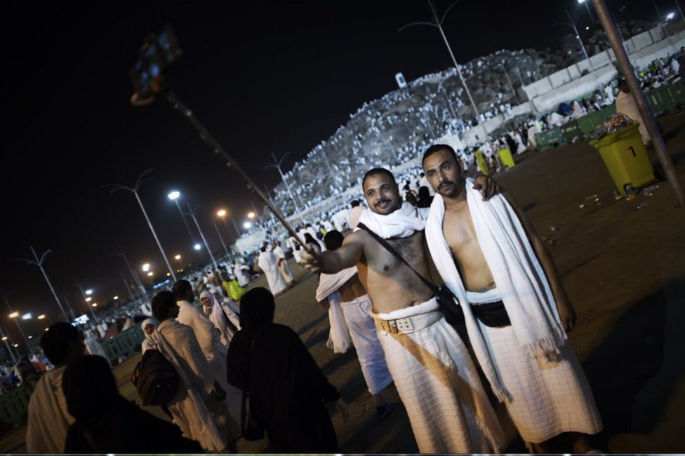 Muslim pilgrims pose for a selfie near Mount Arafat near Mecca early on September 23, 2015. Arafat Day, on the 9th of the Islamic month of Dhul Hijja, is the climax of the hajj season. Pilgrims gather on the hill known as Mount Arafat, and its surrounding plain, where they remain until evening for prayer and Koran recitals. Prophet Mohammed is believed to have delivered his final hajj sermon there.