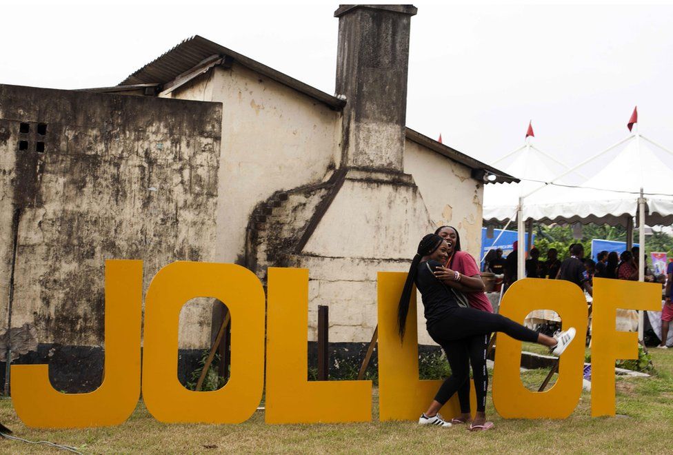 Women hug beside letters reading "Jollof", a popular dish in Nigeria and across West Africa, during the Jollof rice festival in Lagos, on August 20, 2017