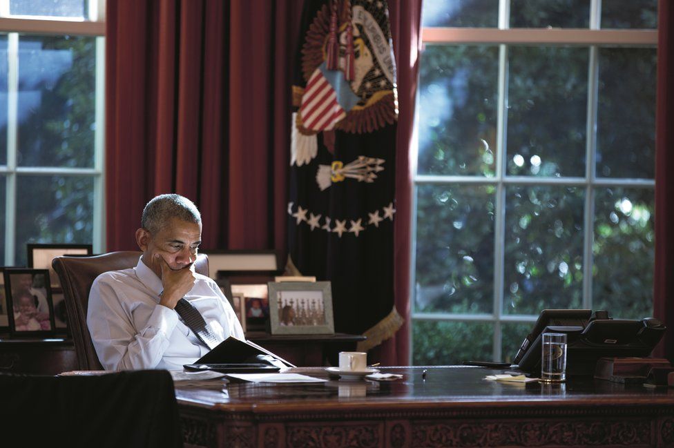 Obama sits at his desk