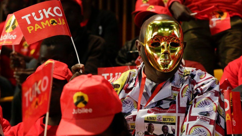 A supporter of Kenya's ruling Jubilee Party supporter dons a mask and a shirt made of canvas with the party leaders pictures printed on at the launch of the manifesto in Nairobi, Kenya, 26 June 2017.