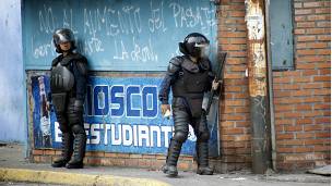 Dos policías se resguardan de las protestas en San Cristobal