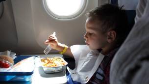 Un niño comiendo en un avión