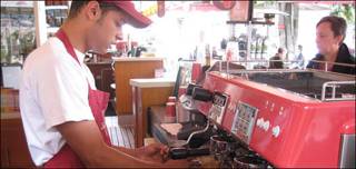 Joven sirve café en Colombia