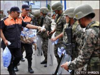 Guarda municipal distribui comida para tropas em frente à embaixada do Brasil em Tegucigalpa