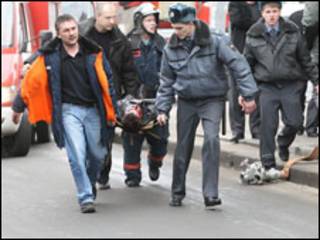 Спасатели несут пострадавшего при взрыве на носилках