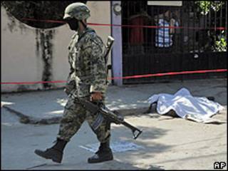 Agente junto a uno de los cadáveres decapitados hallados en Acapulco.