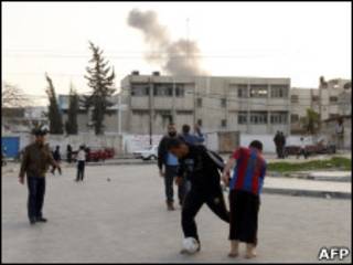 Palestinos jogam bola na Faixa de Gaza durante ataque israelense