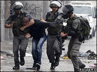 Policial de fronteira israelense prende palestino durante protesto na Cisjordânia, no domingo (Reuters)