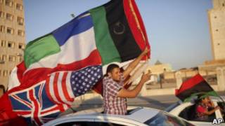 Militante rebelde celebra fim do regime, em Benghazi. AP