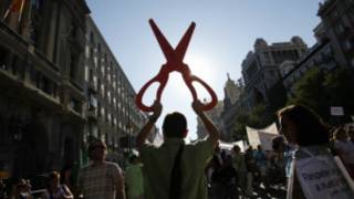 Un hombre empuña una tijera gigante en una manifestación contra los recortes en España