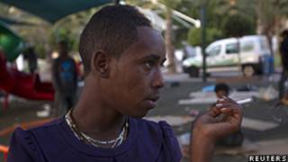 Imigrante fuma cigarro depois de dormir em parque de Tel Aviv (Arquivo/Reuters)