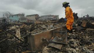 Un bombero recorre una zona de casas devastadas por el paso de la tormenta Sandy en el barrio de Queens, Nueva York