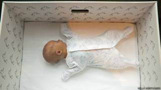Bebé durmiendo en una caja