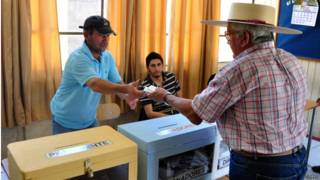 Hombre con sombrero de huaso votando