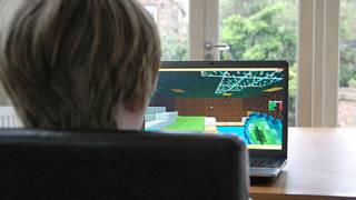 niño frente a computadora jugando Minecraft
