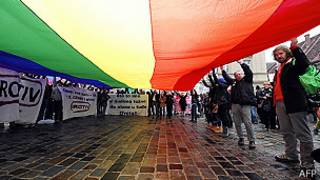 Manifestantes con una bandera del orgullo homosexual