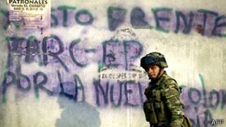 Un soldado colombiano pasa feente a un mural en apoyo a las FARC