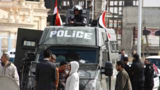 Photo montrant une voiture de police transportant Mohamed Morsi, lors d'une audience de son procès