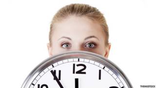 Una empleada detrás de un reloj