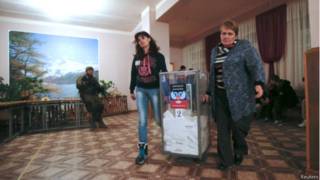 Члены местной избирательной комиссии в Донецке несут урну с бюллетенями после голосования 2 ноября 2014 г.
