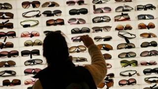 Una mujer ante un stand de gafas de sol