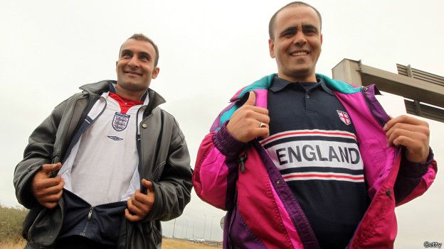 inmigrantes de calais enseñan sus camisetas de equipos de fútbol ingleses.