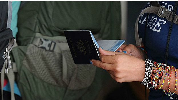 Una mujer sostiene un pasaporte en sus manos. 