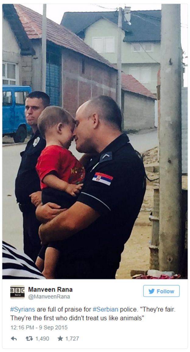 Policía serbio abrazando tiernamente un niño que llegó con su familia migrante
