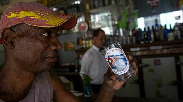 Cubano con un vaso con la imagen del papa