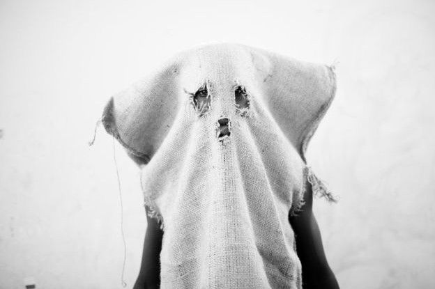 Niño con costal en la cabeza