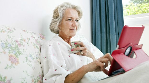 Una adulta mayor usando una tableta