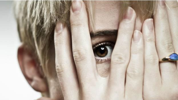 Una persona cubriéndose el rostro