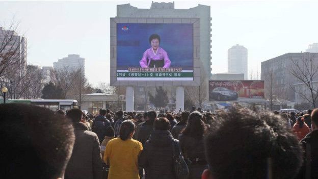 Norcoreanos viendo el anuncio del lanzamiento del cohete en una pantalla gigante en Pyongyang