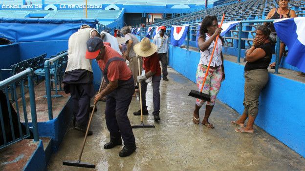 Trabajadores del estadio Latinoamericano limpian los pisos como preparativo para el partido de béisbol entre los Tampa Bay Rays y el equipo nacional de béisbol cubano