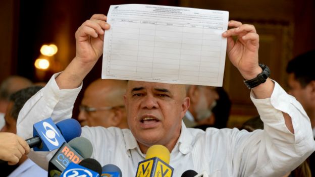 Jesús Torrealba, portavoz de la oposición, muestra una planilla de recolección de firmas para el referéndum
