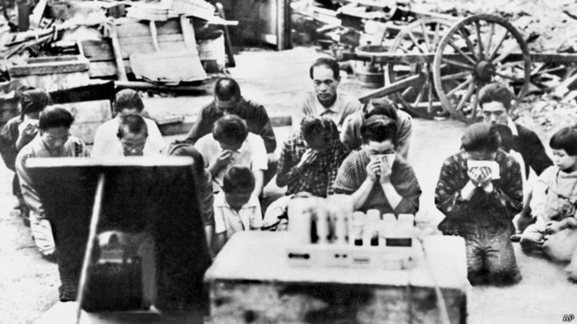 Japoneses escuchan el anuncion de rendición del emperador Hiroito